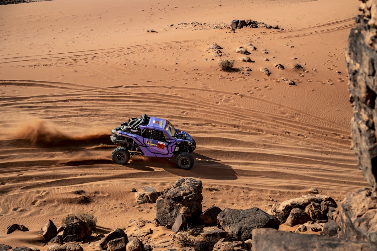 Aerial style shot of the Vendetta UTV traversing red dunes between rocks. Photo by Irina Petrichei.